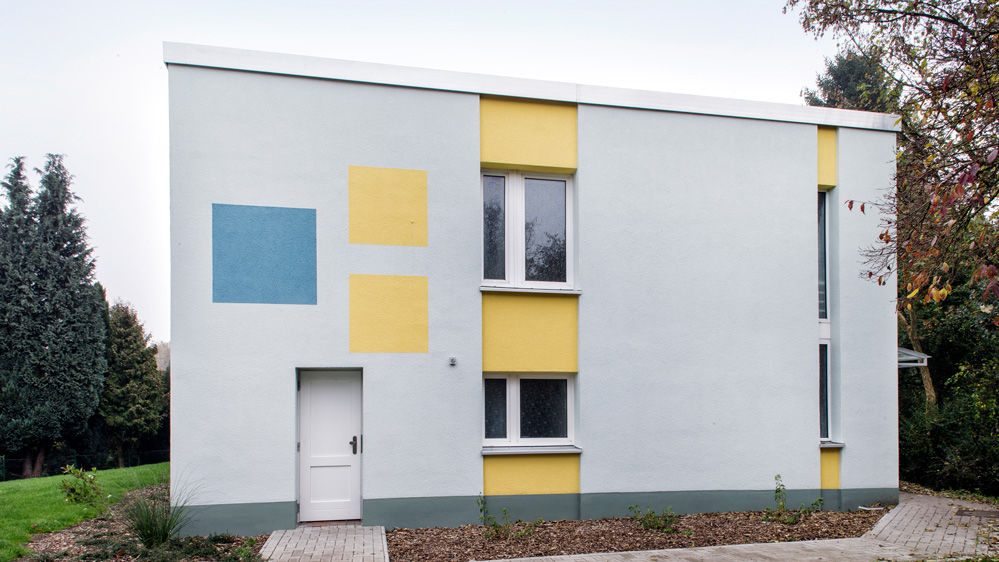 Modernes Wohnhaus mit blau-gelb-weißer Fassade
